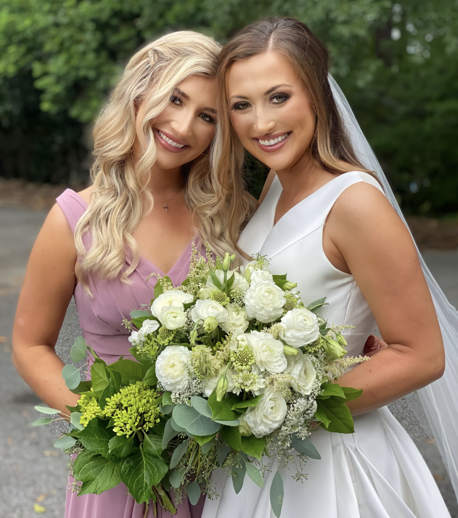 Beautiful bride, McKenzie, smiles for the camera with her sister and Maid of Honor, Madeline.
