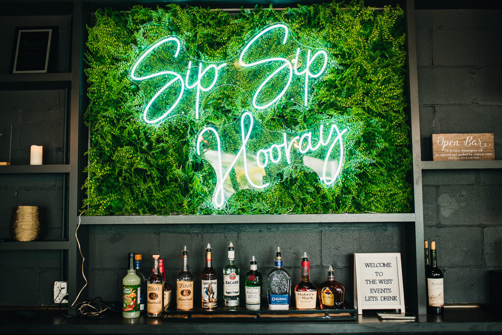 neon bar sign that reads "Sip Sip Hooray" at reception at The West End