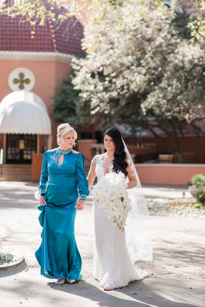 mom walks bride down the aisle lush white wedding florals on Socialite Event Planning Orlando