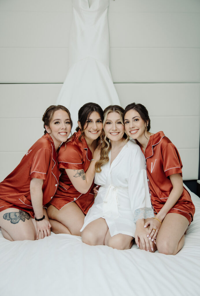 bride and bridesmaids wearing matching silk pajamas at Caribe Royals Orlando