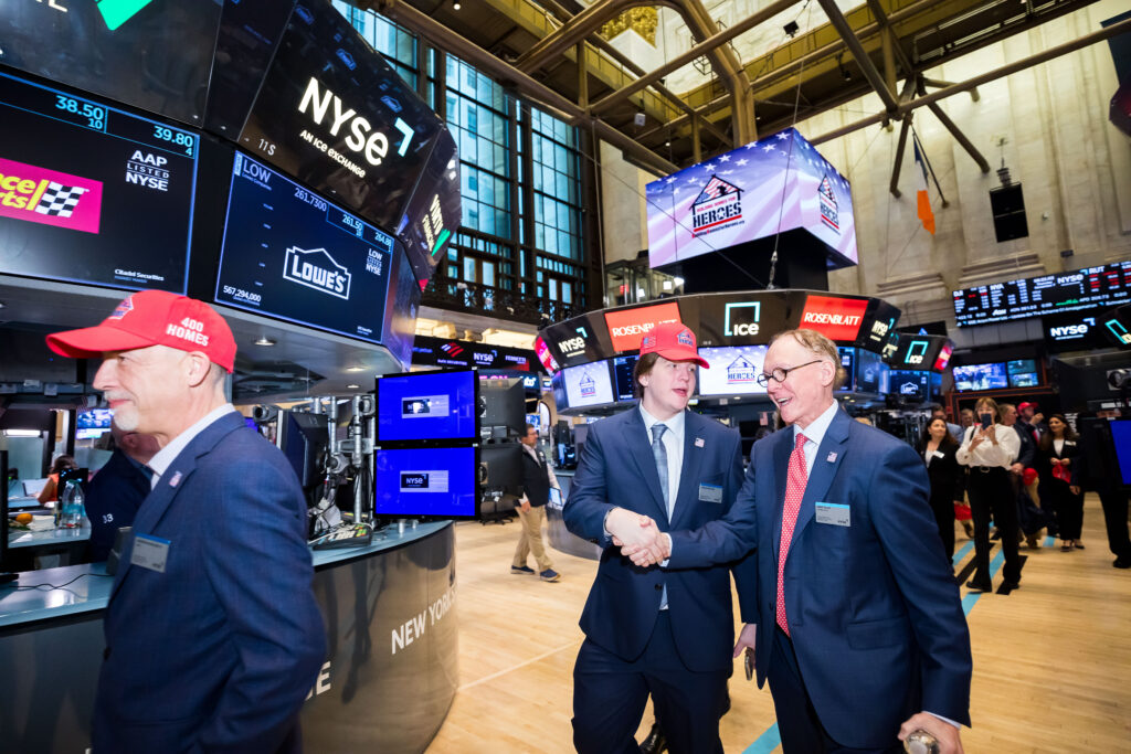 three men in Building Homes for Herores hats at NYSE