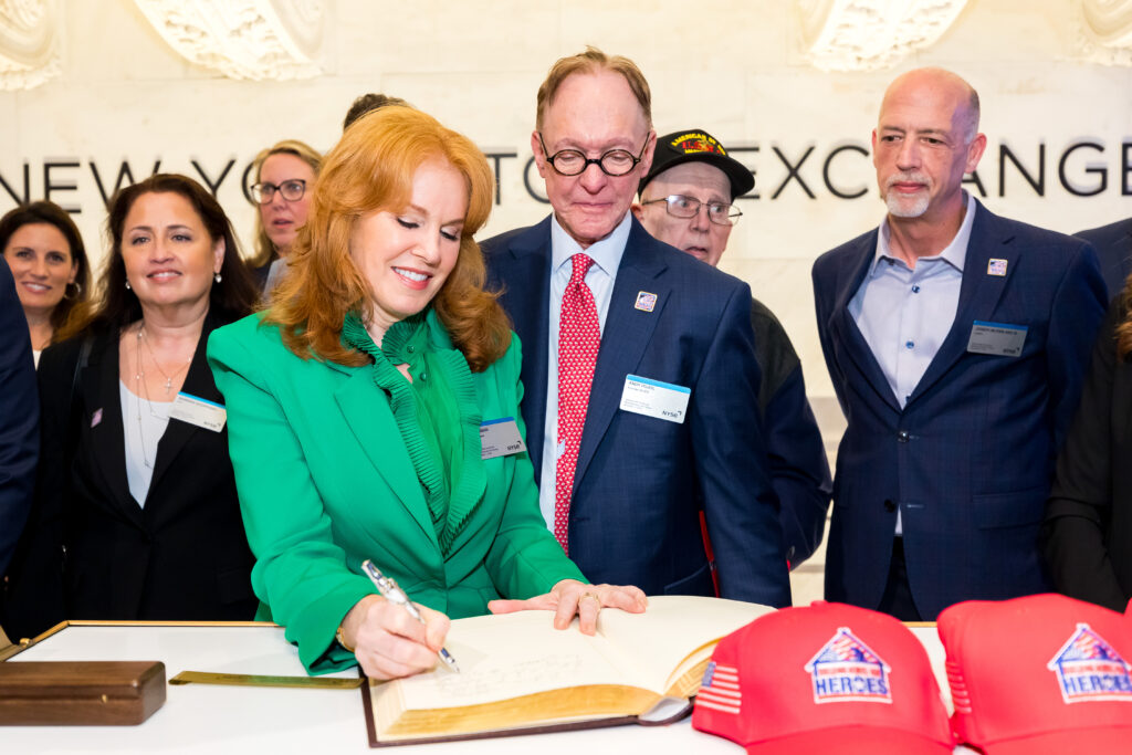 woman in a green dress signing book at NYSE