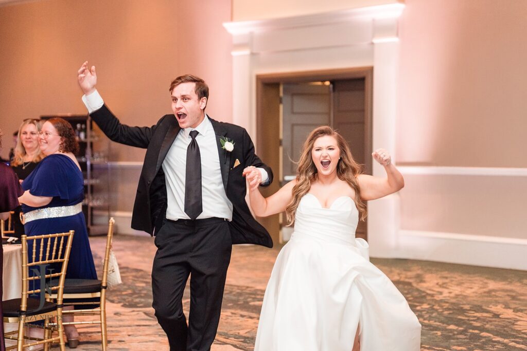 bride and groom cheering as they enter wedding reception