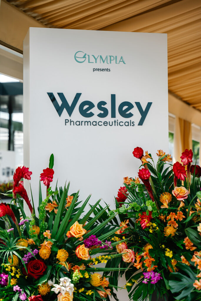 creative event signage adorned with lush tropical florals at event planned by Socialite Event Planning Florida